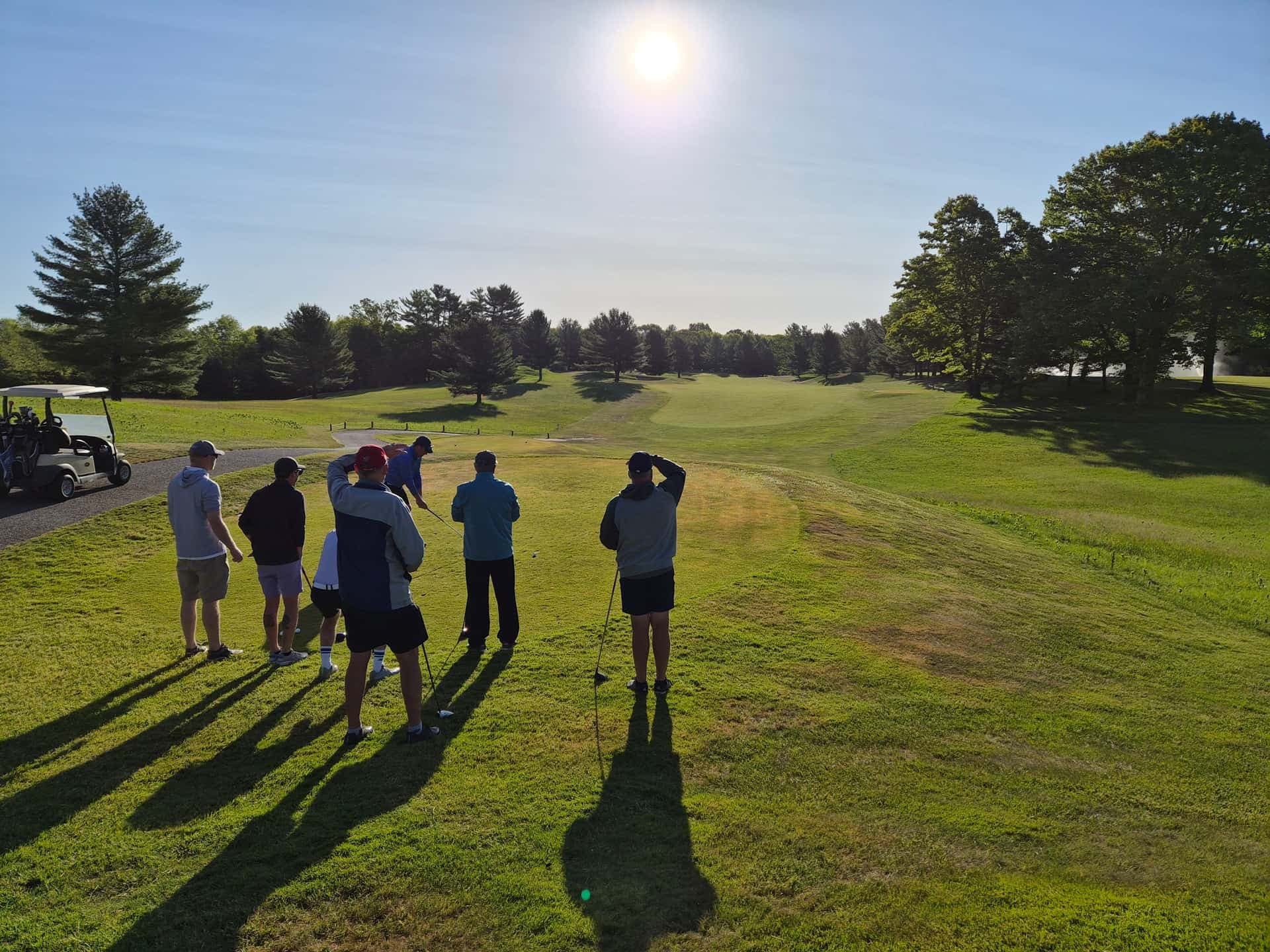 Golfer teeing off at sunrise